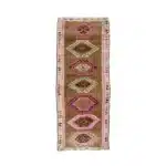 Brown turkish carpet runner with pink and cream diamond medallions.