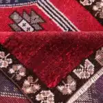 Folded corner of a red wool turkish carpet