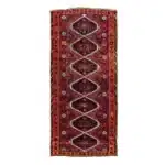 hand-knotted turkish carpet with red, navy, and cream diamond medallions.