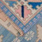 turkish carpet showing blue, pink, and cream tribal motifs