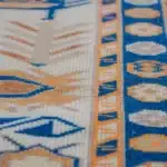 turkish carpet with blue medallions, bird motifs, and an orange-blue geometric border.