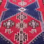 turkish carpet with navy diamond medallions and a floral border.