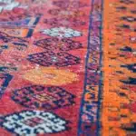 turkish carpet with red, navy, and cream diamond medallions.